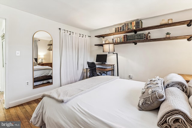 bedroom featuring baseboards and hardwood / wood-style flooring