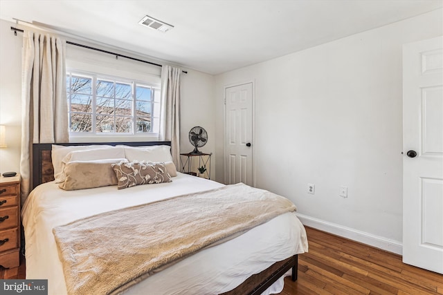 bedroom featuring visible vents, wood-type flooring, and baseboards