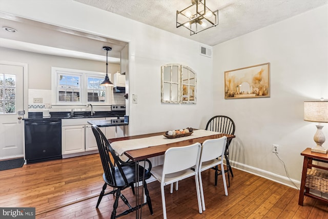 dining area featuring a wealth of natural light, visible vents, baseboards, and hardwood / wood-style floors