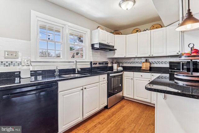 kitchen featuring under cabinet range hood, white cabinets, appliances with stainless steel finishes, and a sink