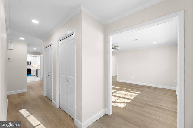 hallway featuring ornamental molding and light wood-type flooring