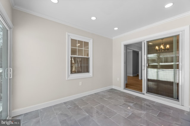 spare room with ornamental molding and an inviting chandelier