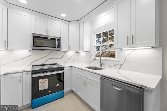 kitchen with stainless steel appliances, sink, and white cabinets