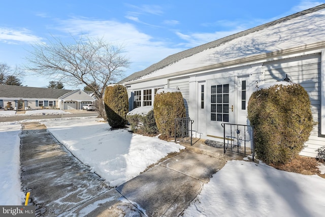 snow covered patio featuring a garage