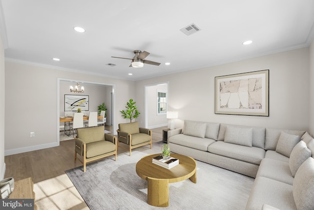 living room featuring crown molding, wood-type flooring, and ceiling fan with notable chandelier