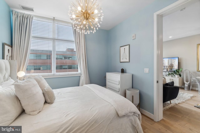 bedroom featuring light hardwood / wood-style flooring and a notable chandelier