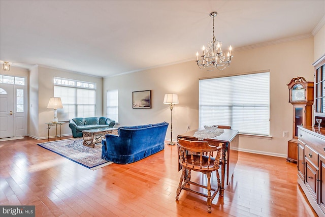 dining space featuring a notable chandelier, ornamental molding, and light hardwood / wood-style floors