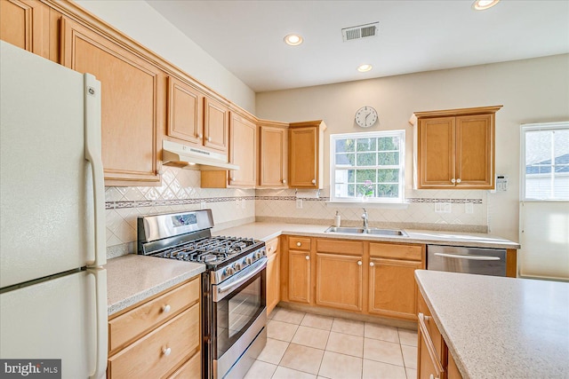 kitchen with appliances with stainless steel finishes, sink, and light tile patterned floors