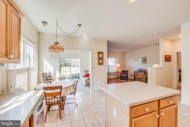 kitchen with light tile patterned floors, hanging light fixtures, and a center island