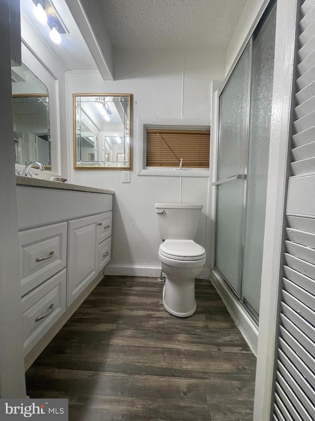 bathroom with hardwood / wood-style flooring, vanity, an enclosed shower, toilet, and a textured ceiling