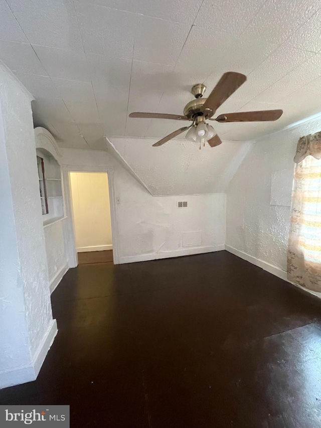 additional living space with vaulted ceiling, ceiling fan, and a textured ceiling