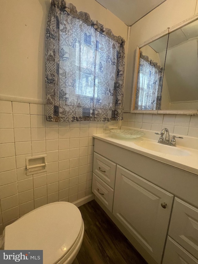 bathroom with tile walls, vanity, hardwood / wood-style flooring, and toilet