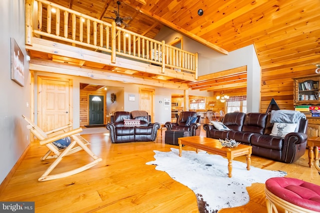 living room with hardwood / wood-style flooring, a high ceiling, ceiling fan with notable chandelier, and wood ceiling