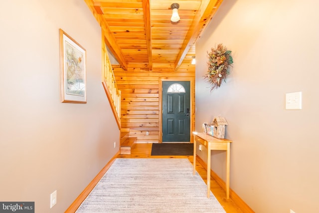 foyer with hardwood / wood-style flooring, wooden ceiling, beam ceiling, and wood walls