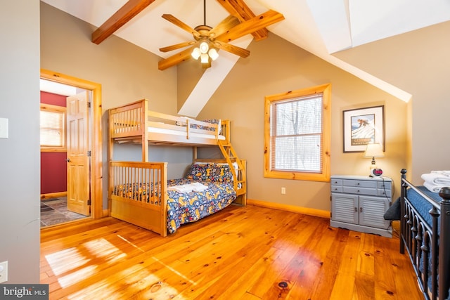 bedroom with hardwood / wood-style floors, multiple windows, and vaulted ceiling with beams