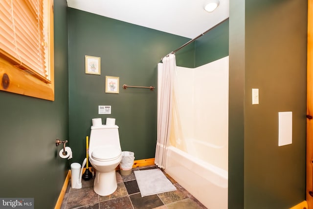 bathroom with shower / bath combination with curtain and toilet