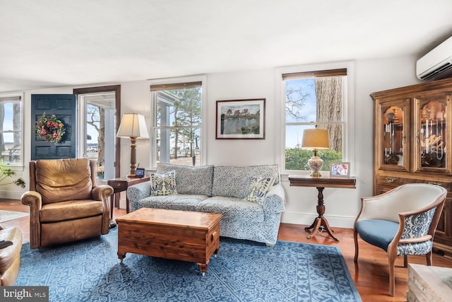 living room featuring plenty of natural light, hardwood / wood-style floors, and an AC wall unit