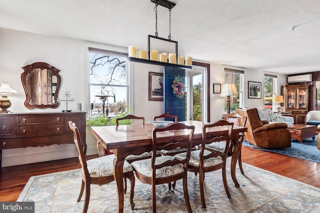 dining room with hardwood / wood-style floors and a wall unit AC