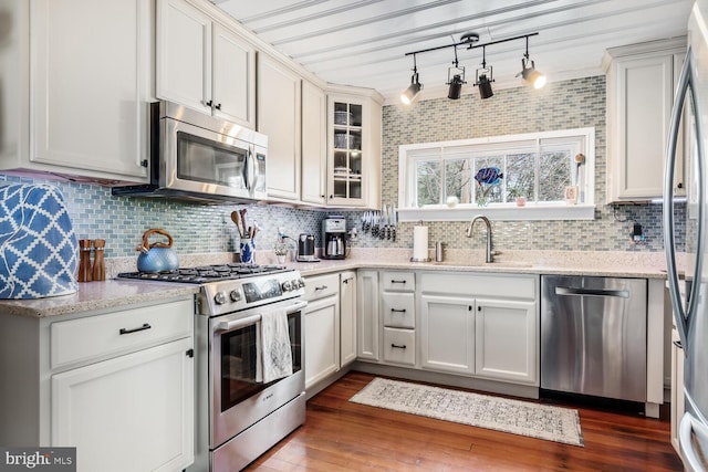 kitchen with white cabinetry, appliances with stainless steel finishes, sink, and light stone counters