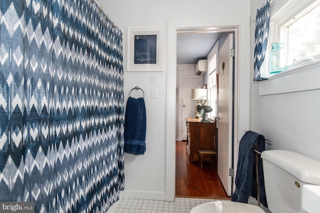 bathroom with a wall mounted air conditioner and toilet