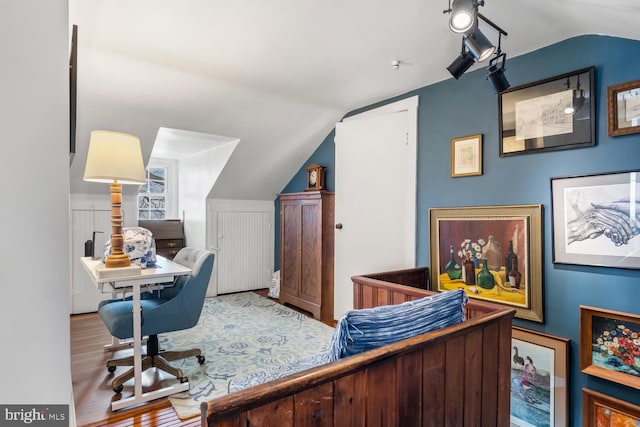 home office featuring wood-type flooring and lofted ceiling