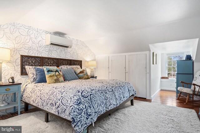 bedroom with wood-type flooring, vaulted ceiling, and an AC wall unit