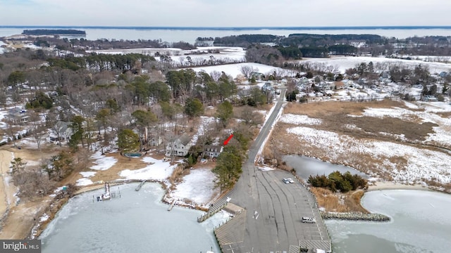 snowy aerial view featuring a water view