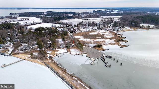 snowy aerial view featuring a water view