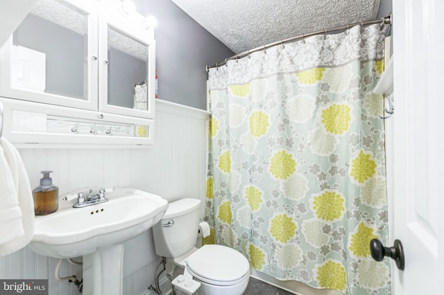 bathroom with a shower with shower curtain, wood walls, a textured ceiling, and toilet