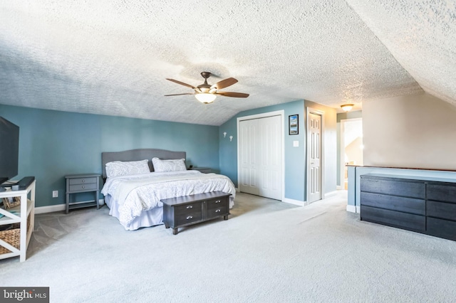 bedroom featuring vaulted ceiling, light carpet, a textured ceiling, and ceiling fan