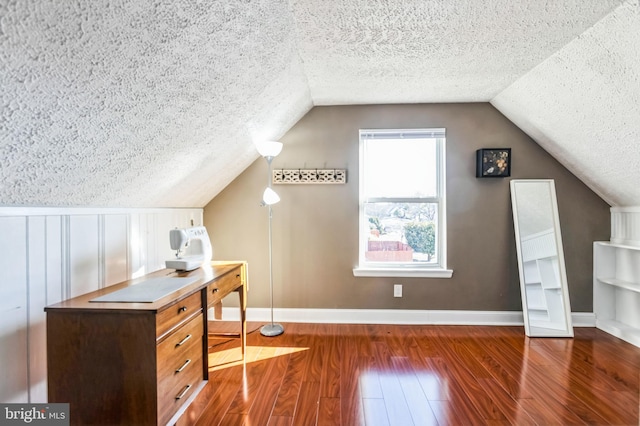 bonus room with lofted ceiling, dark wood-type flooring, and a textured ceiling