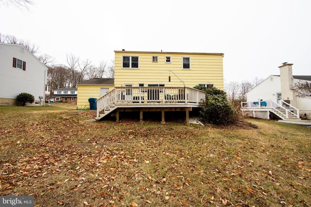 back of property featuring a wooden deck and a lawn