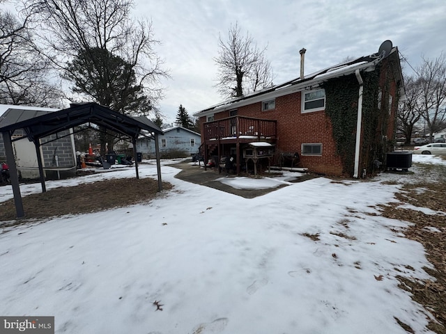 snowy yard with central AC unit and a deck