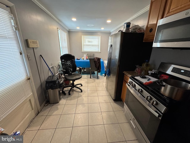 kitchen with ornamental molding, appliances with stainless steel finishes, and light tile patterned floors