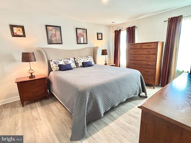 bedroom featuring multiple windows and light hardwood / wood-style floors