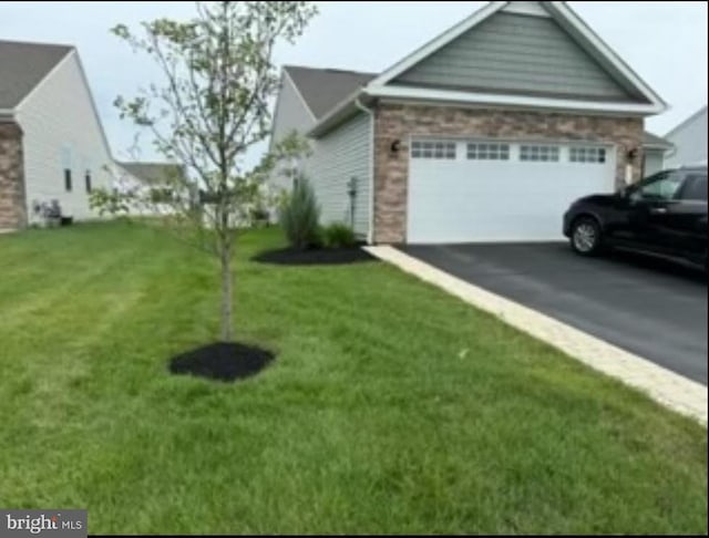 view of side of home with a garage and a lawn