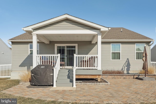 rear view of house featuring a patio and covered porch