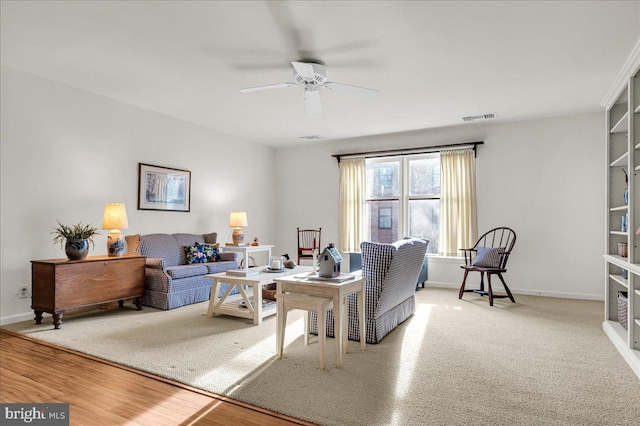 living room featuring wood-type flooring and ceiling fan