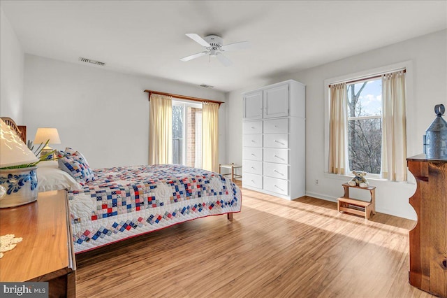 bedroom with multiple windows, ceiling fan, and light wood-type flooring