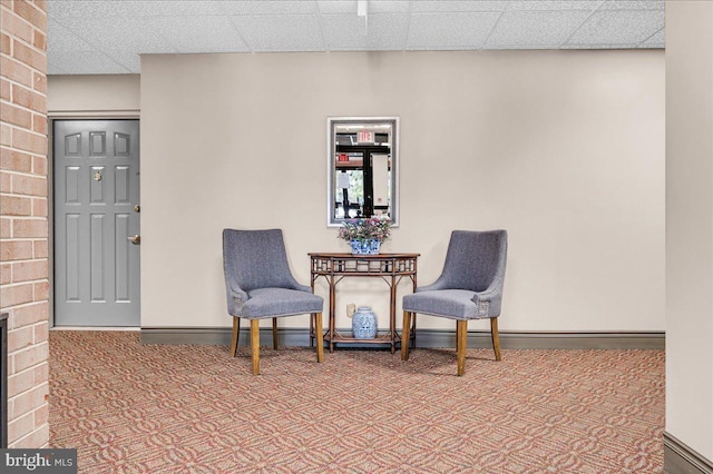 living area with a paneled ceiling