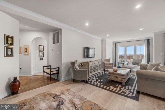 living room featuring crown molding and light hardwood / wood-style flooring