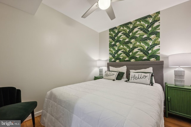 bedroom featuring lofted ceiling, hardwood / wood-style flooring, radiator heating unit, and ceiling fan