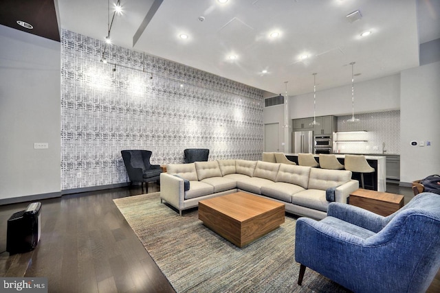 living room featuring a towering ceiling and wood-type flooring