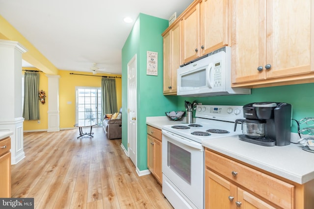 kitchen with decorative columns, light wood-type flooring, light brown cabinetry, and white appliances