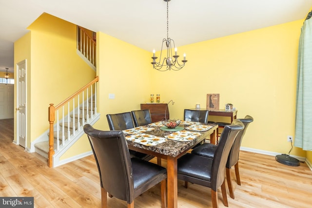 dining space featuring an inviting chandelier and light wood-type flooring