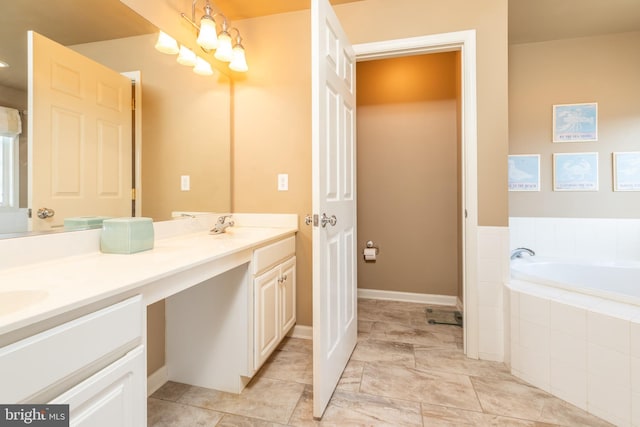 bathroom with vanity and tiled tub