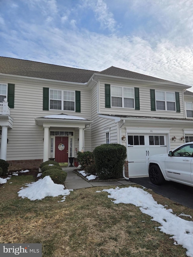 view of front of home with a garage and a lawn