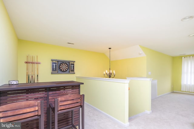 bar featuring pendant lighting, light colored carpet, lofted ceiling, and a chandelier