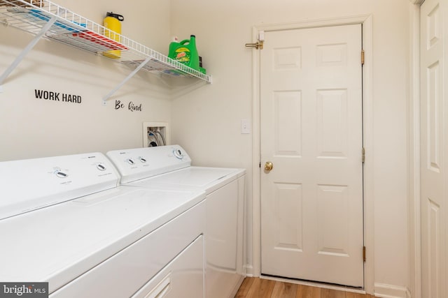 laundry area with light hardwood / wood-style flooring and washing machine and clothes dryer