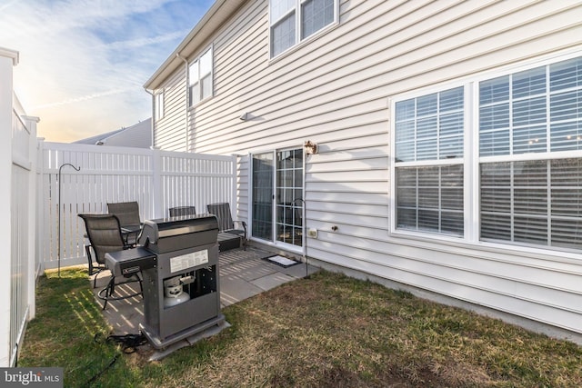 patio terrace at dusk with grilling area and a lawn